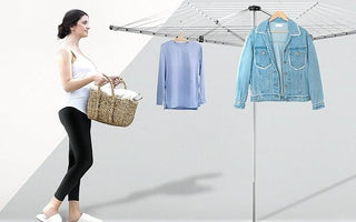 Woman with woven basket using modern outdoor rotary clothes drying rack holding blue shirt and denim jacket