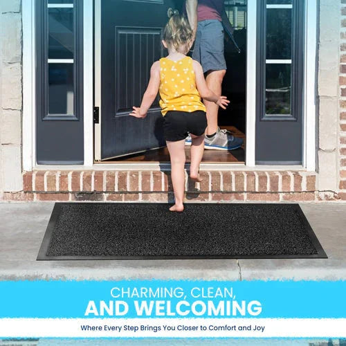 Child walking barefoot on black non-slip rubber door mat outside brick home entrance