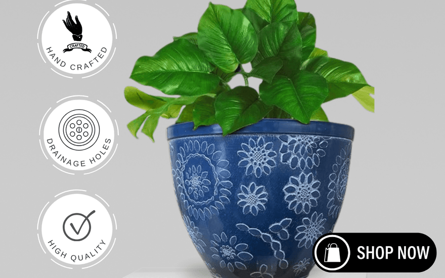 Handcrafted blue Chengdu plant pot with white floral patterns and green foliage on white pedestal