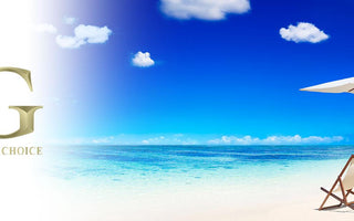 Beach scene with two lounge chairs under a white umbrella on white sand and calm blue ocean